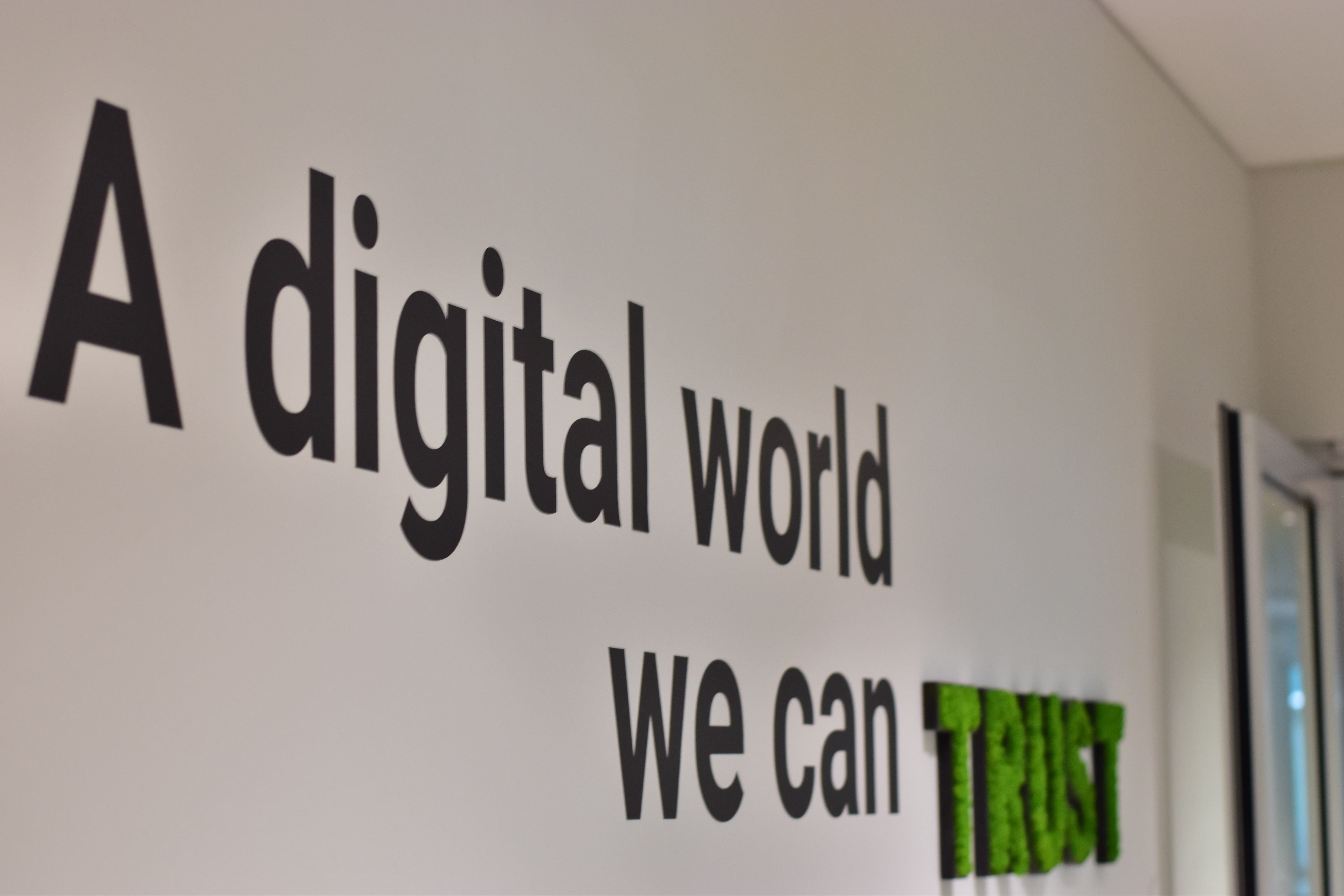 Una foto de la oficina de Trusted Shops con el eslogan «A digital world you can trust» (Un mundo digital en el que puedes confiar) en la pared.