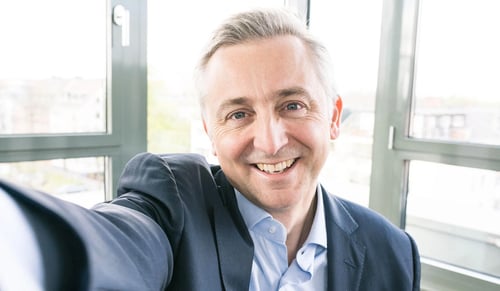 El CEO de Trusted Shops, Jean-Marc Noel, sonríe a la cámara y se hace un selfi en su oficina.