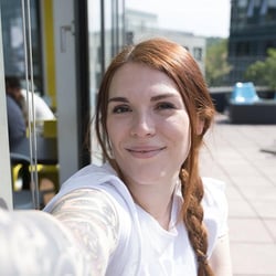 Una empleada de Trusted Shops sonríe para hacerse un selfie.
